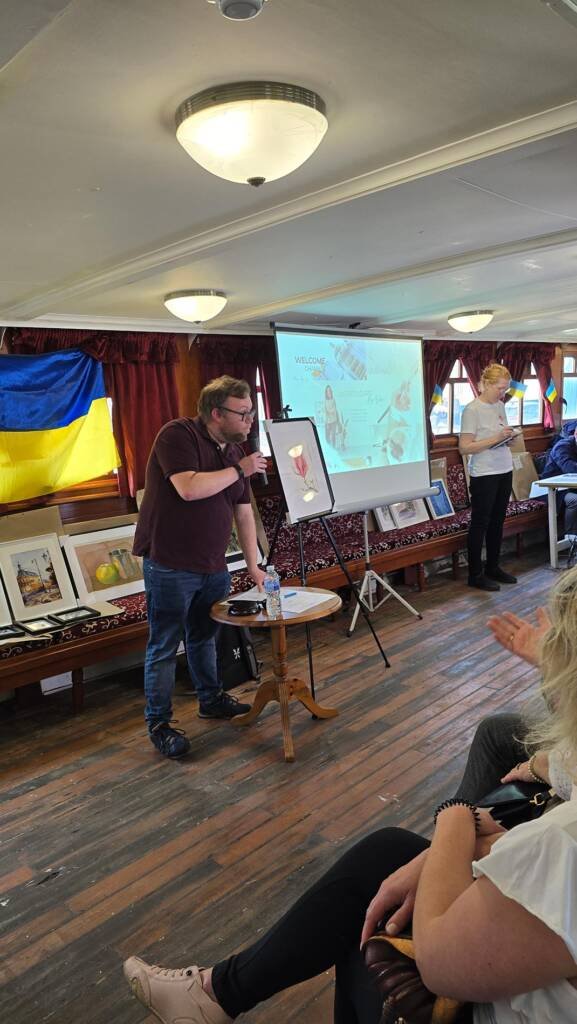 Live auction in progress aboard the Medway Queen during the “Art for Peace” charity event supporting Ukraine.