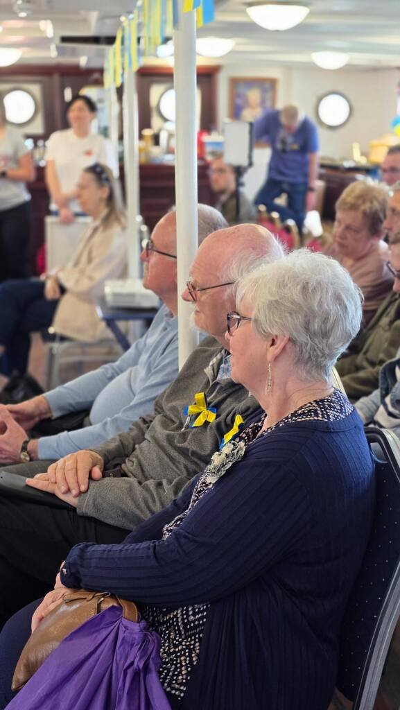 Audience attentively watching the “Art for Peace” charity auction aboard the Medway Queen.