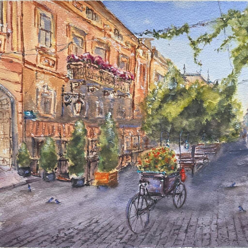 Award-winning watercolor painting “Morning Stillness on Kobylianska” by Aliya Bodnar, depicting a peaceful street scene with orange facades, flowers, and a bicycle.