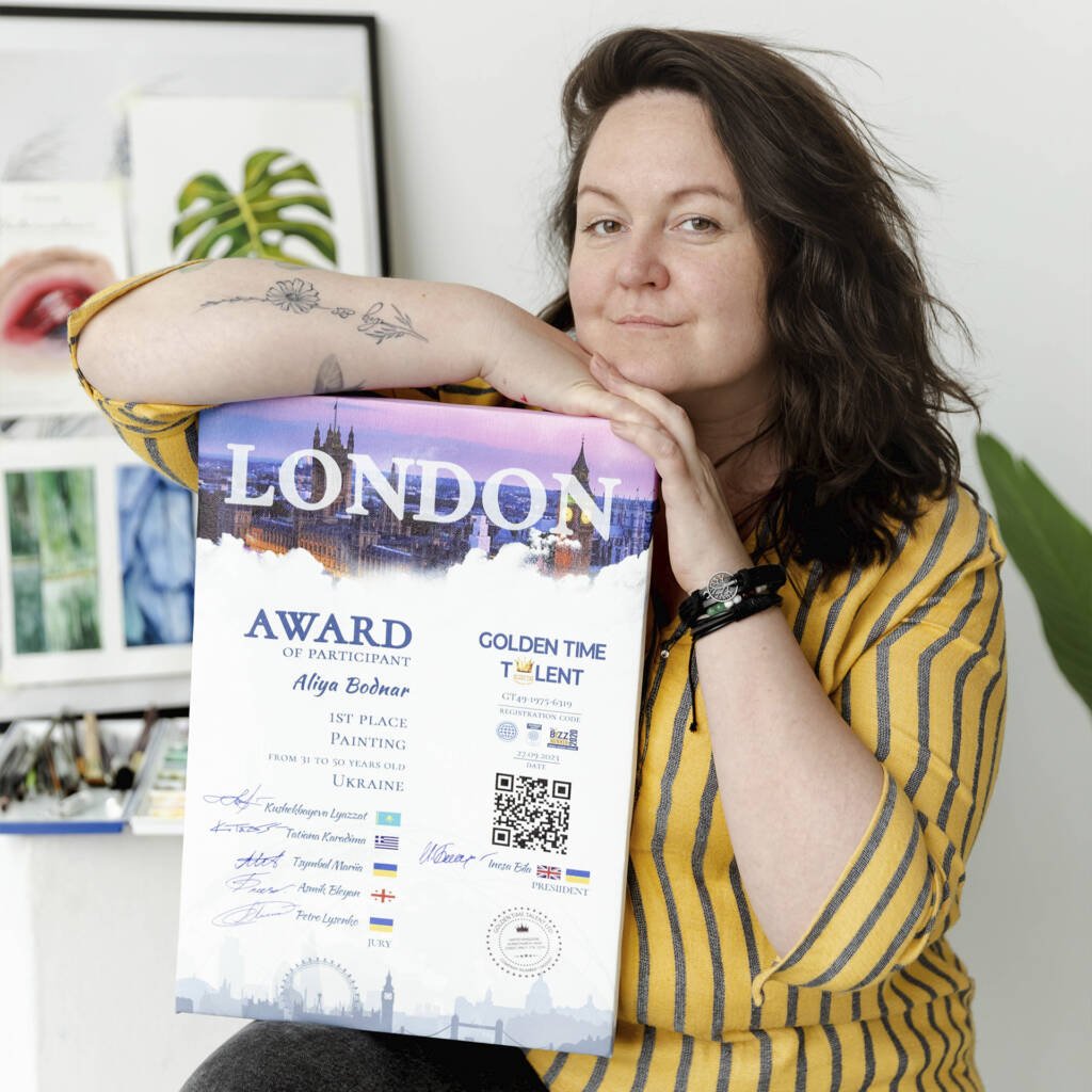 Aliya Bodnar holding her Global Talent Confederation diploma and smiling proudly.