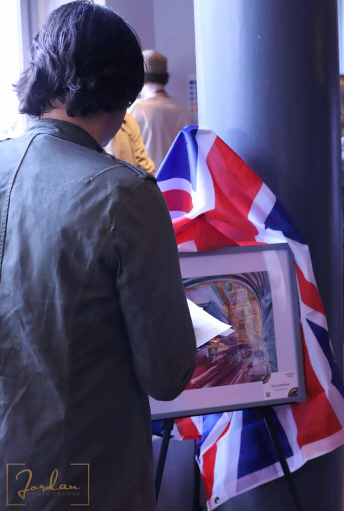 A judge carefully assessing Aliya Bodnar’s watercolor painting during the World Talent Award 2024 exhibition.