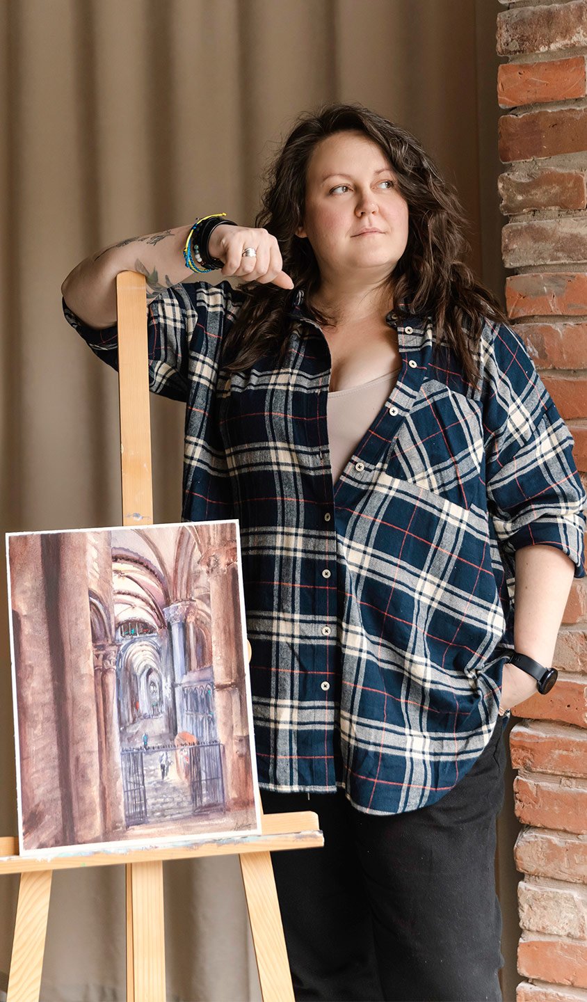 Aliya Bodnar holding her original watercolor painting in studio