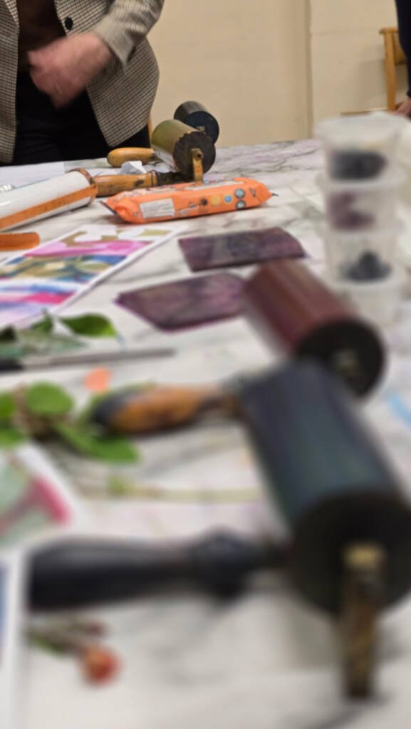 Art workshop in progress with participants painting at a long shared table during a Rochester & West Kent Art Society event.