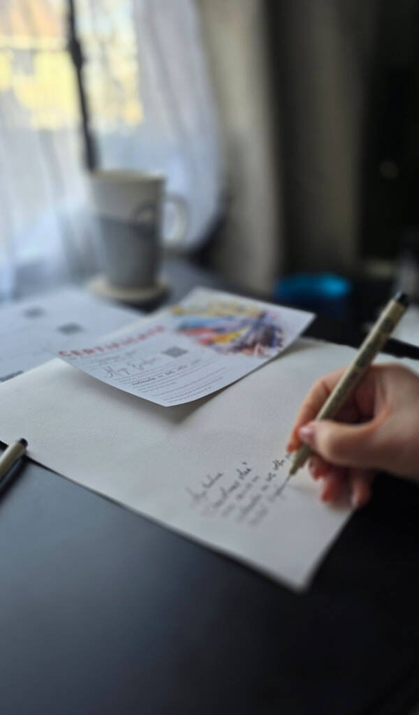 Artist Aliya Bodnar signing her original watercolour artwork before packaging.
